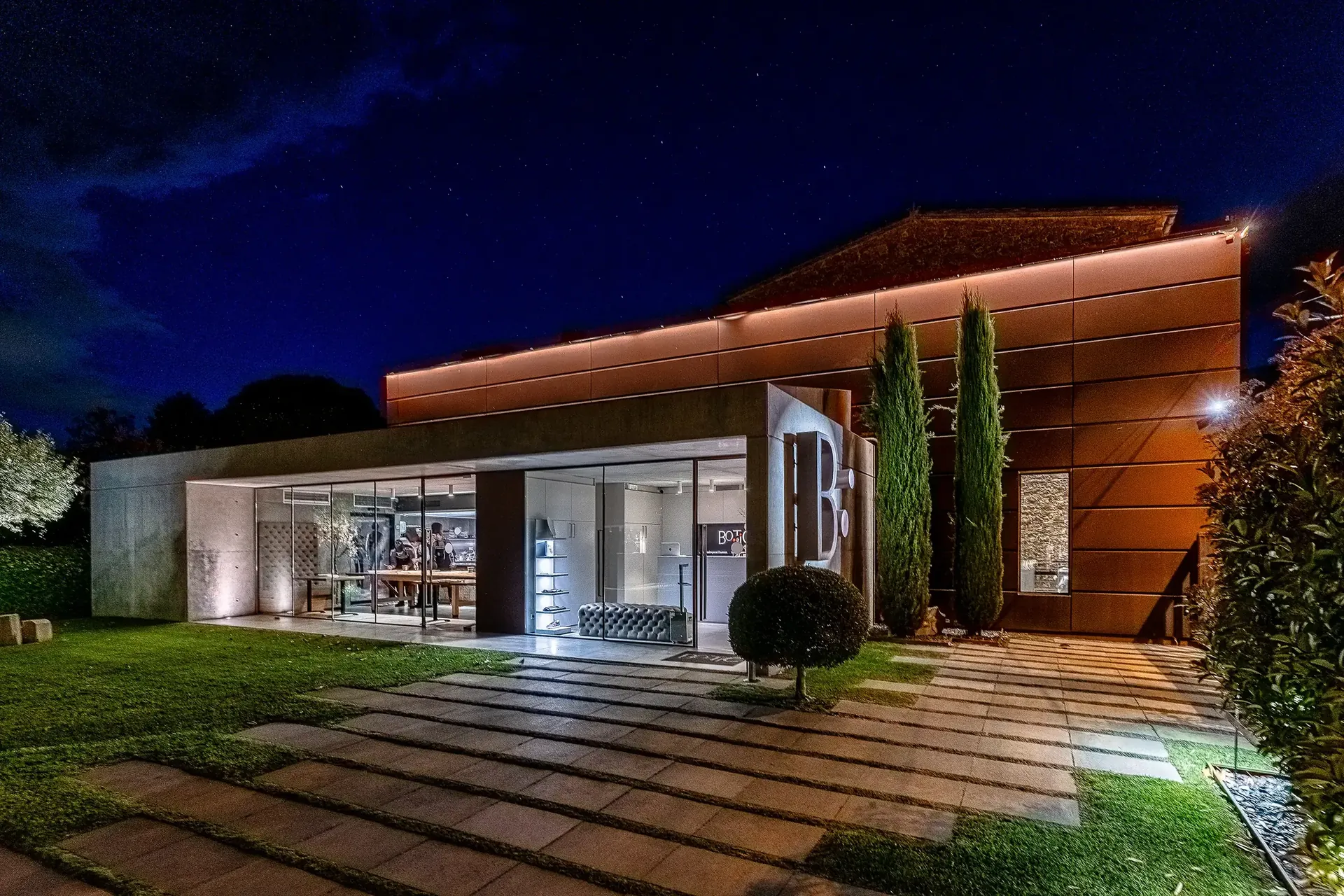 Fachada iluminada de noche del restaurante Bo.TiC en Corçà, en el Empordà.