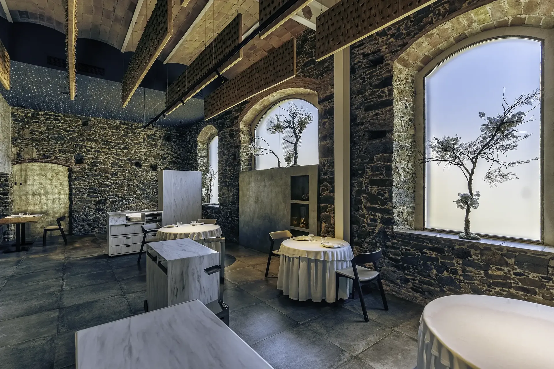 Sala del restaurante Bo.TiC con paredes de piedra y luz natural